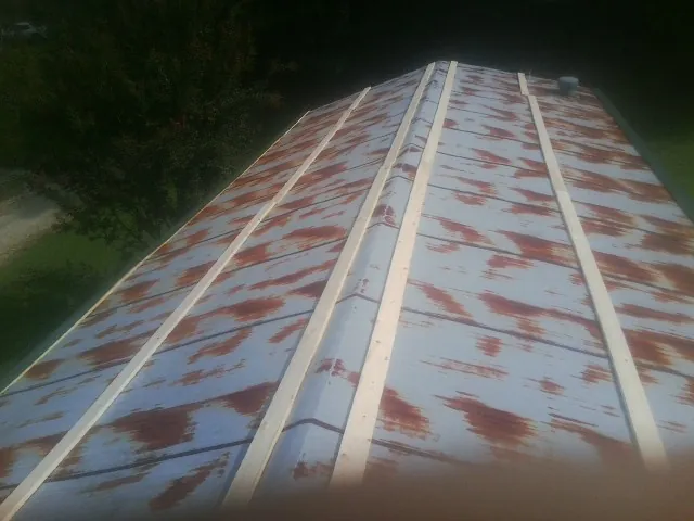 Rusted metal roof panels with new wood purlins before replacement — Storm Damage Roof Repair in Roaring River by Roofing Brothers