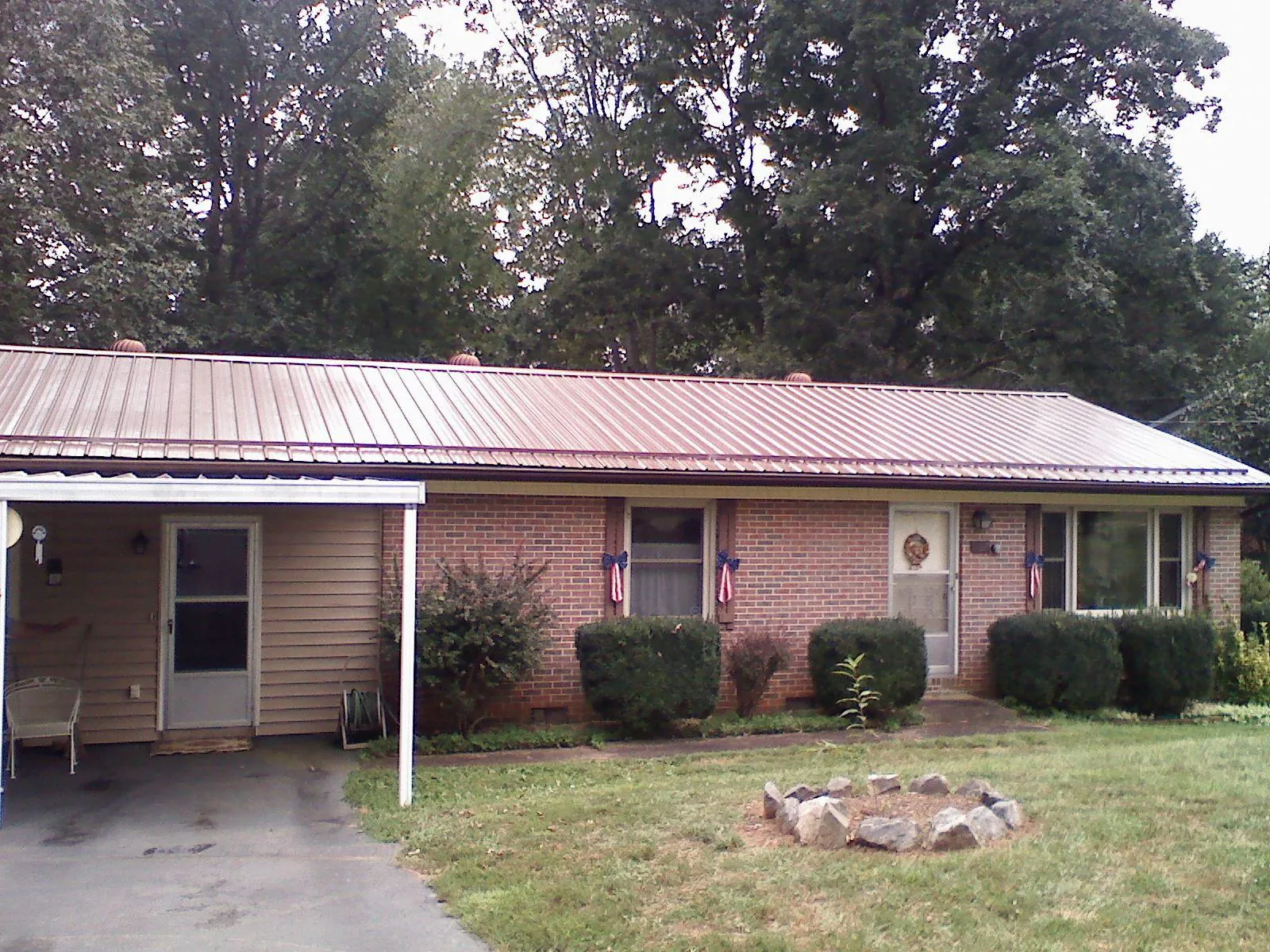 Bronze metal roof and carport on a brick ranch home — Roof Repair work by our crew in Roaring River